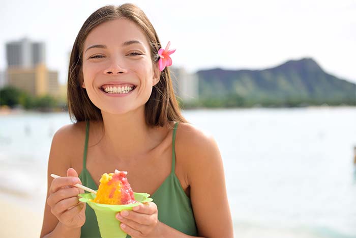 girl enjoying a snow cone at the beach